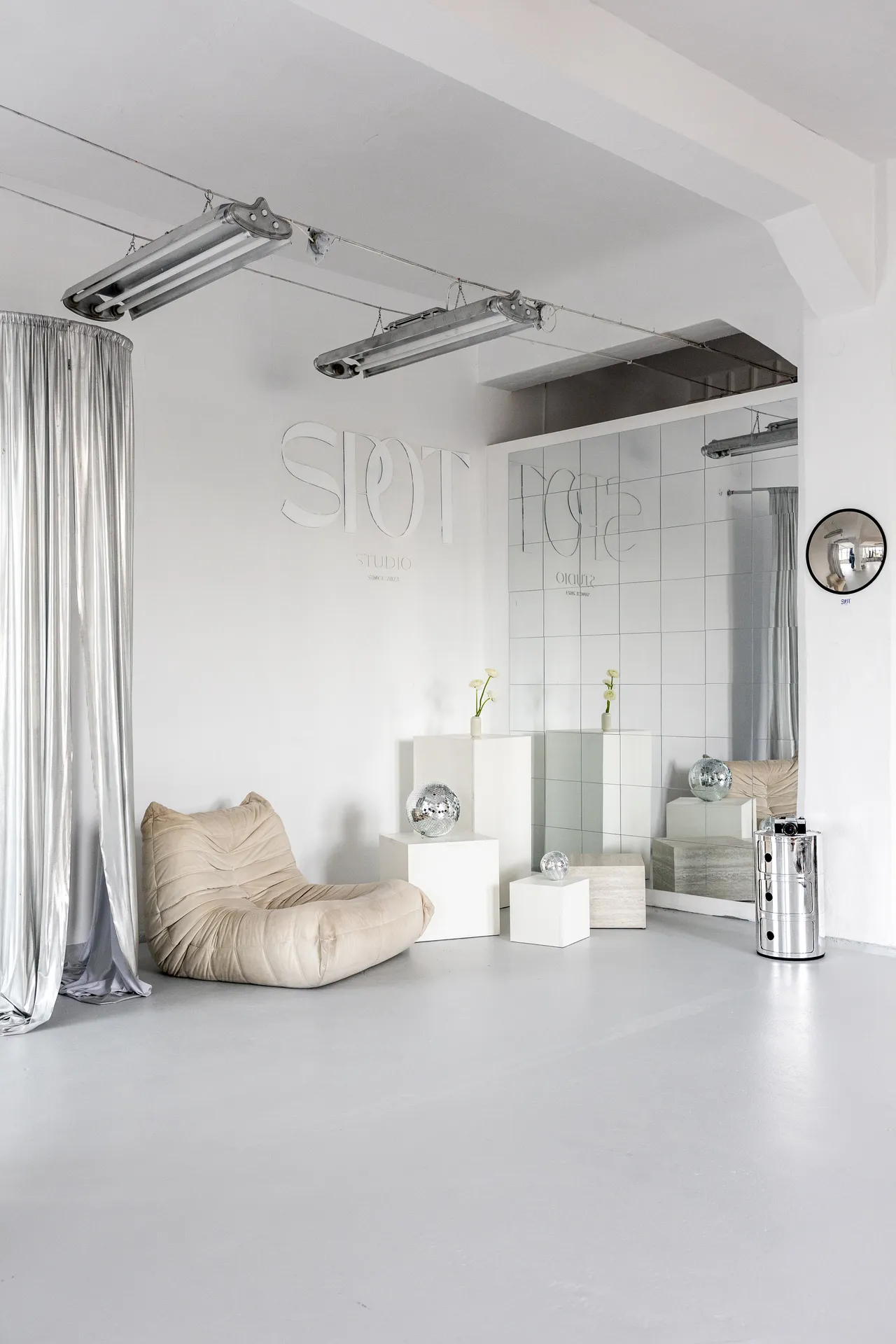Studio fotograficzne SPOT Wrocław, wnętrze z pufą Togo, kulami disco i ścianą z logo SPOT Studio